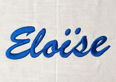 Broderie textile personnalisée en Ariège 9 Prénom Éloïse brodé en bleu sur textile blanc